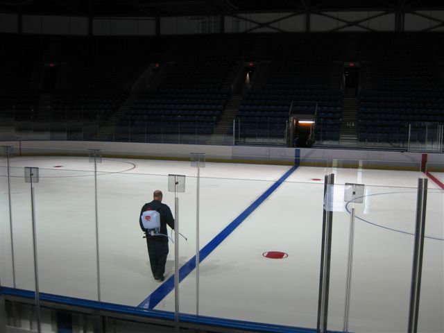 man paints blue line on ice